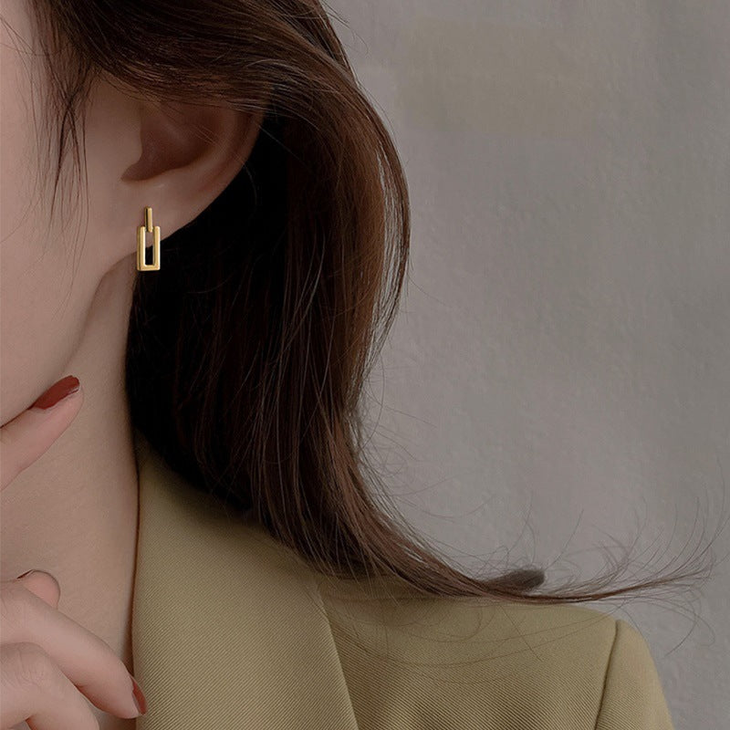  A pair of gold rectangular drop earrings with a sleek, modern design
