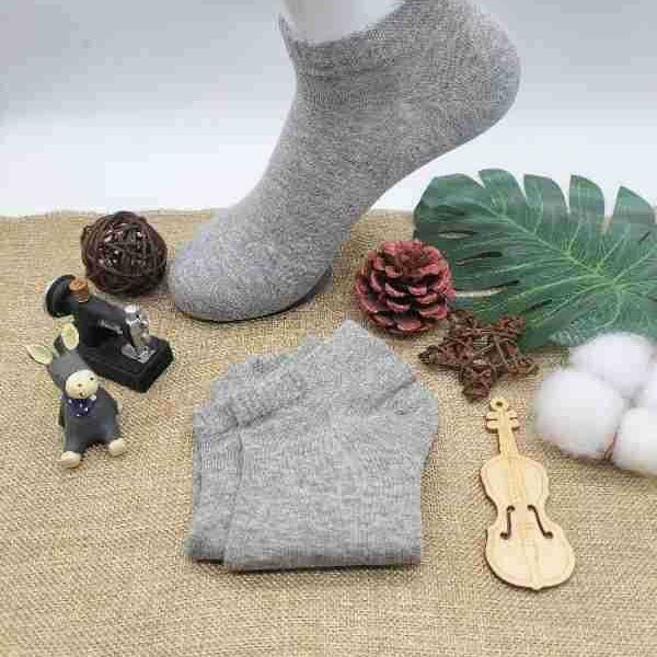 Heather gray ankle socks displayed with decorative elements - wooden violin, pine cone, monstera leaf, and cotton balls