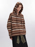 Woman with hood up modeling brown striped zip hoodie with chevron pattern detail, paired with black denim skirt and olive green accent belt