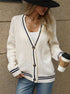 White cable knit cardigan with navy trim, paired with white tank and black wide-brim hat for chic casual look