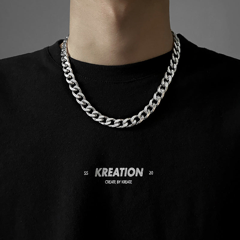 Thick silver curb chain necklace worn with black t-shirt