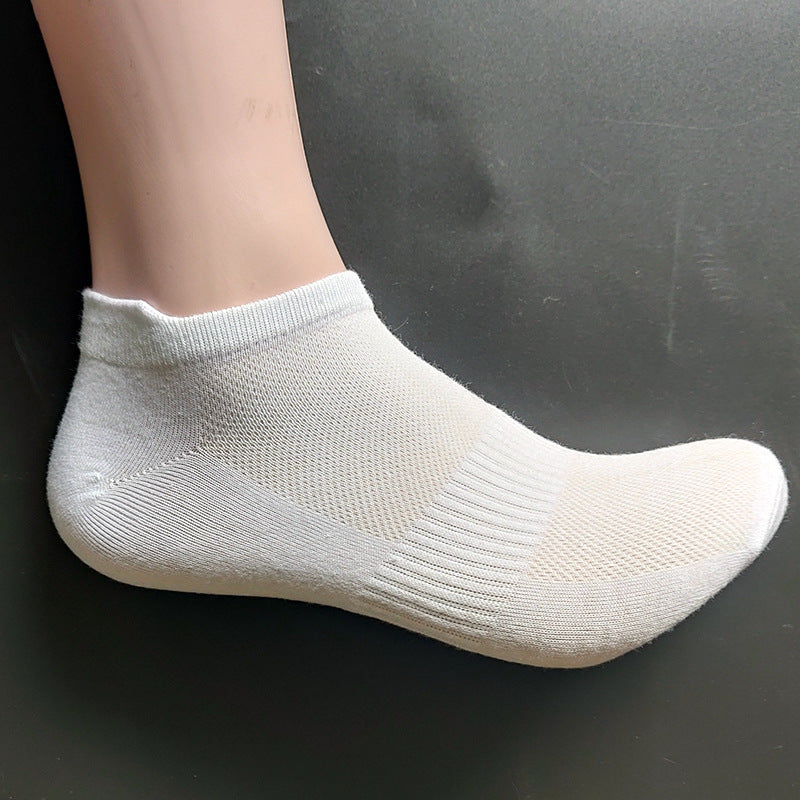 White ankle sock displayed on mannequin foot showing mesh ventilation design, cushioned sole and snug-fitting elastic cuff against dark background