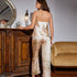 Back view of a cream satin pajama set with floral botanical print, displayed near an ornate mirror and vintage furniture