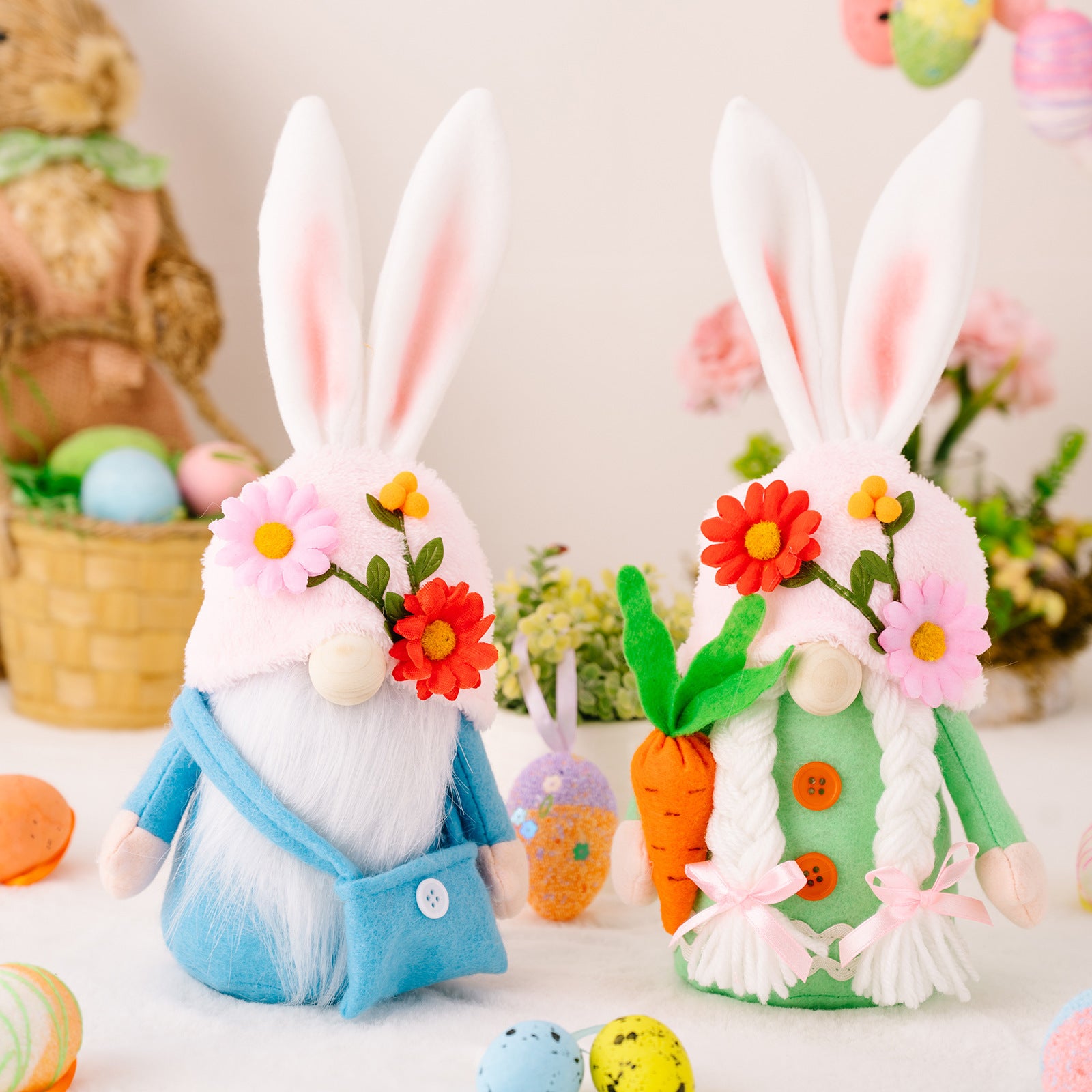  Two plush Easter bunny gnomes with long ears, floral hats, and soft beards, dressed in blue and green, displayed on a festive spring background.