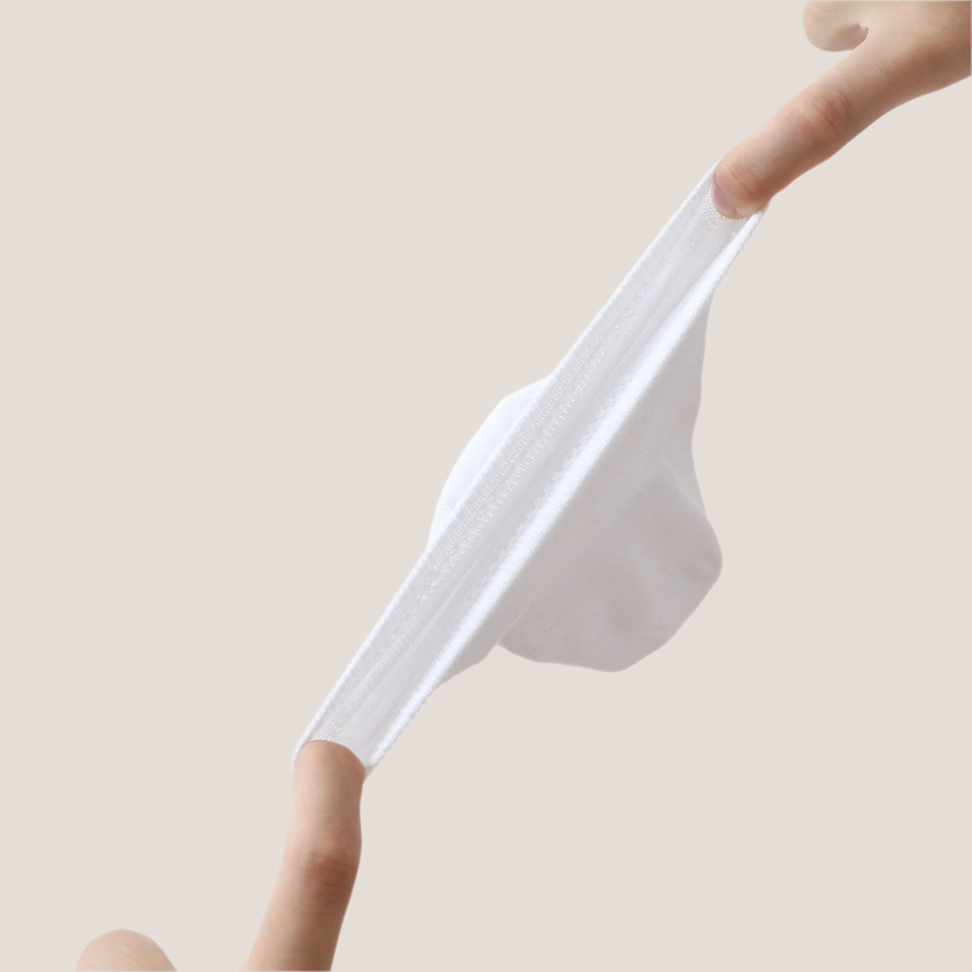 Close-up of white sock demonstrating stretch capability and flexible mesh material with ribbed elastic band