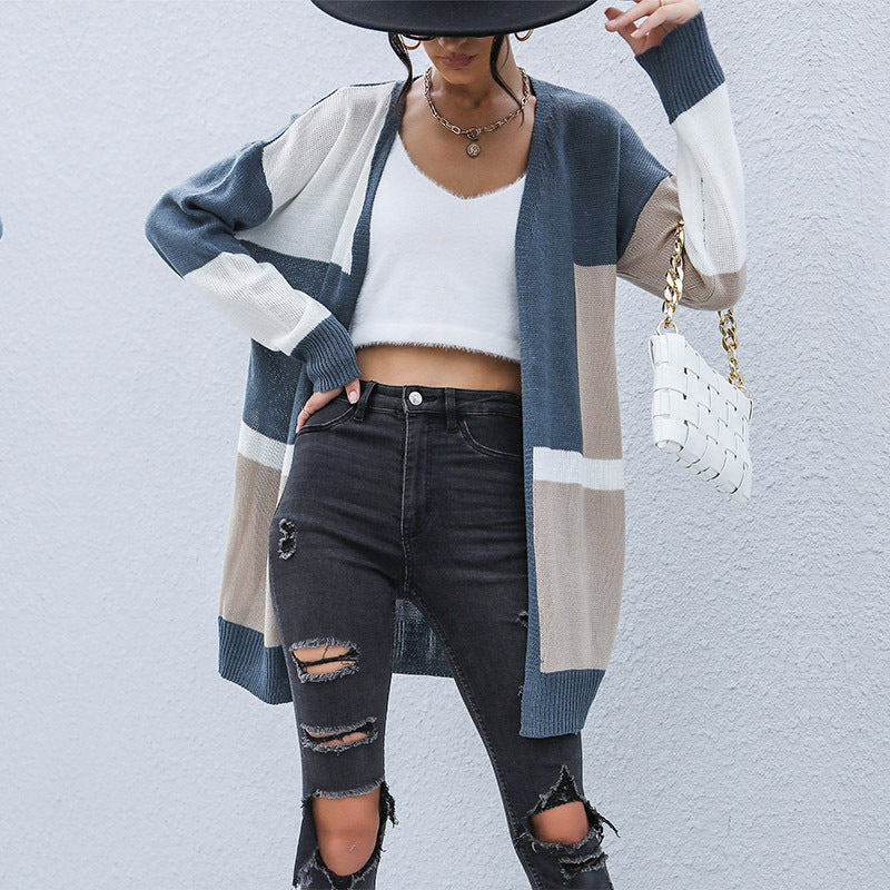 Casual outfit with colorblock cardigan, white crop top, ripped black jeans, and white woven handbag