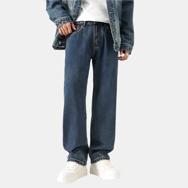 A model is wearing dark blue wide-leg jeans with a denim jacket and white top, standing against a white background
