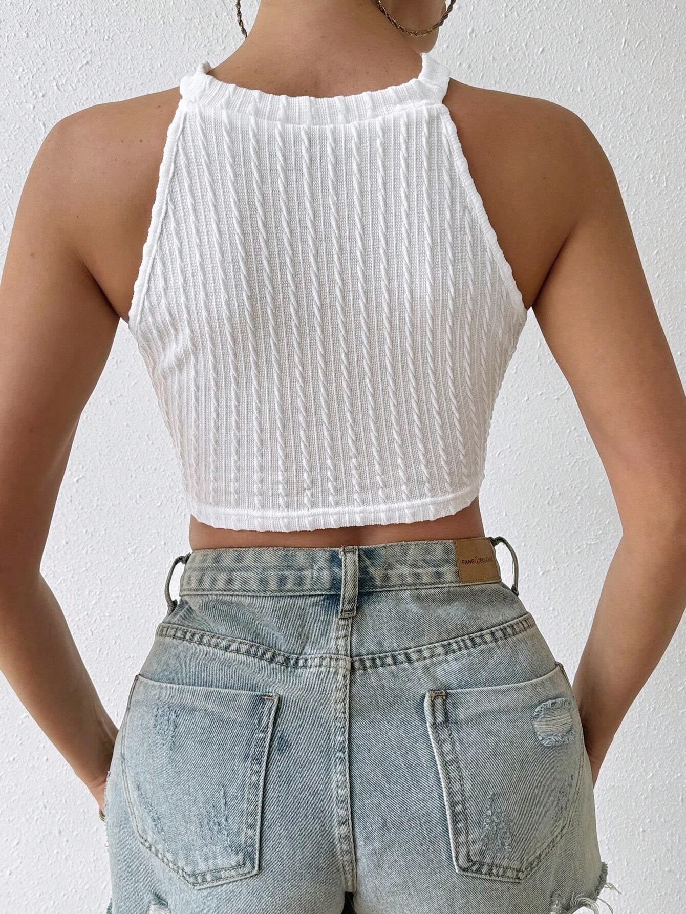 Back view of white ribbed knit halter crop top paired with distressed denim shorts.