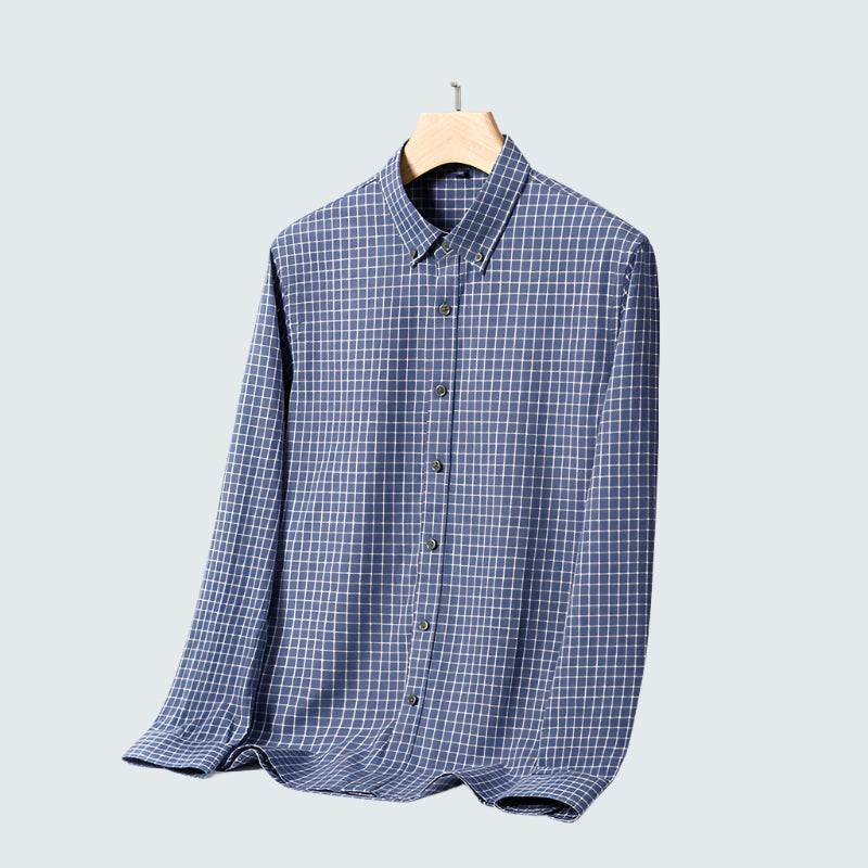 Navy blue checkered shirt on wooden hanger. Button-down collar and small white grid pattern for casual style