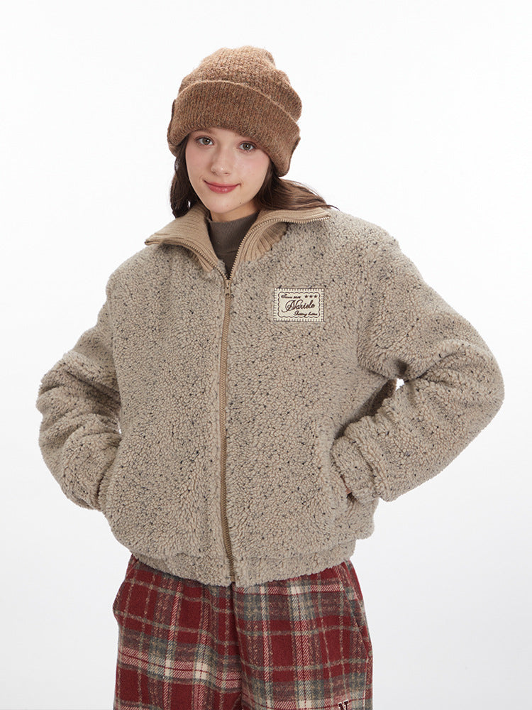 Model wearing beige teddy fleece jacket with Marule patch, brown beanie and red plaid pants. Cozy winter style against white backdrop