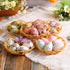 Assorted vintage-style Easter eggs with floral and bunny prints arranged in decorative woven baskets on a cozy table setting.