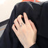 Silver lightning bolt ring on hand wearing black clothing