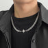 Titanium Steel Cuban chain necklace with central crystal starburst pendant, styled on model wearing black t-shirt and shirt.
