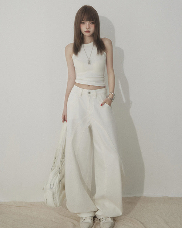 Front view of white wide-leg jeans with curved seam detail, styled with white crop top.