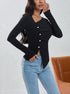 Side view of fitted black button-front top with ruched detail and asymmetric hem worn with denim