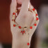 Elegant red agate bracelet with maple leaf charm and gold-tone details