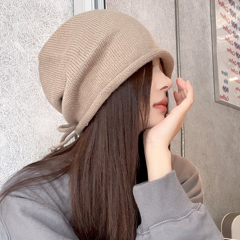 Side profile of beige beanie hat styled with casual grey sweatshirt
