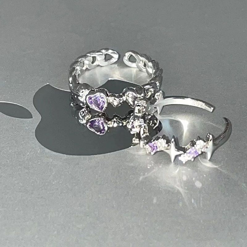 Silver adjustable rings with purple heart gemstones casting shadows on gray surface - heartbeat design and chain style with double heart detail