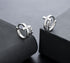 Silver cross hoop earrings with zircon accents on gray backdrop