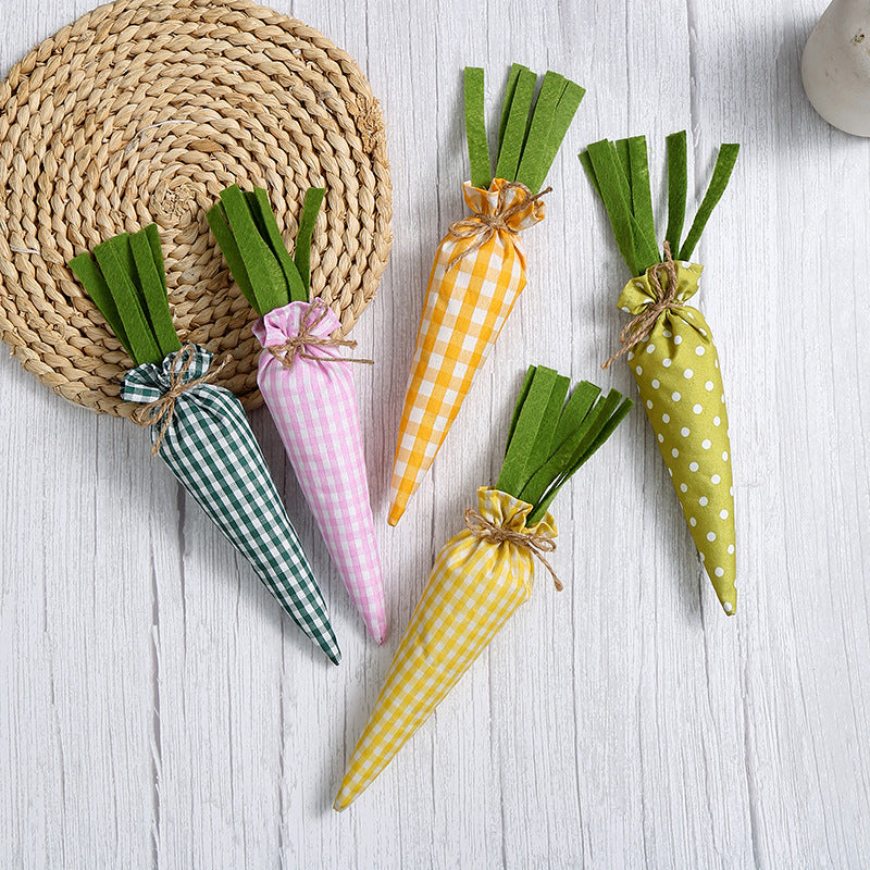 A set of five fabric carrots with gingham and polka dot patterns in green, yellow, pink, and orange, placed on a woven mat.