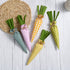 A set of five fabric carrots with gingham and polka dot patterns in green, yellow, pink, and orange, placed on a woven mat.