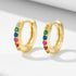 A pair of gold 925 huggie hoop earrings with rainbow gemstones displayed on white background with soft shadow