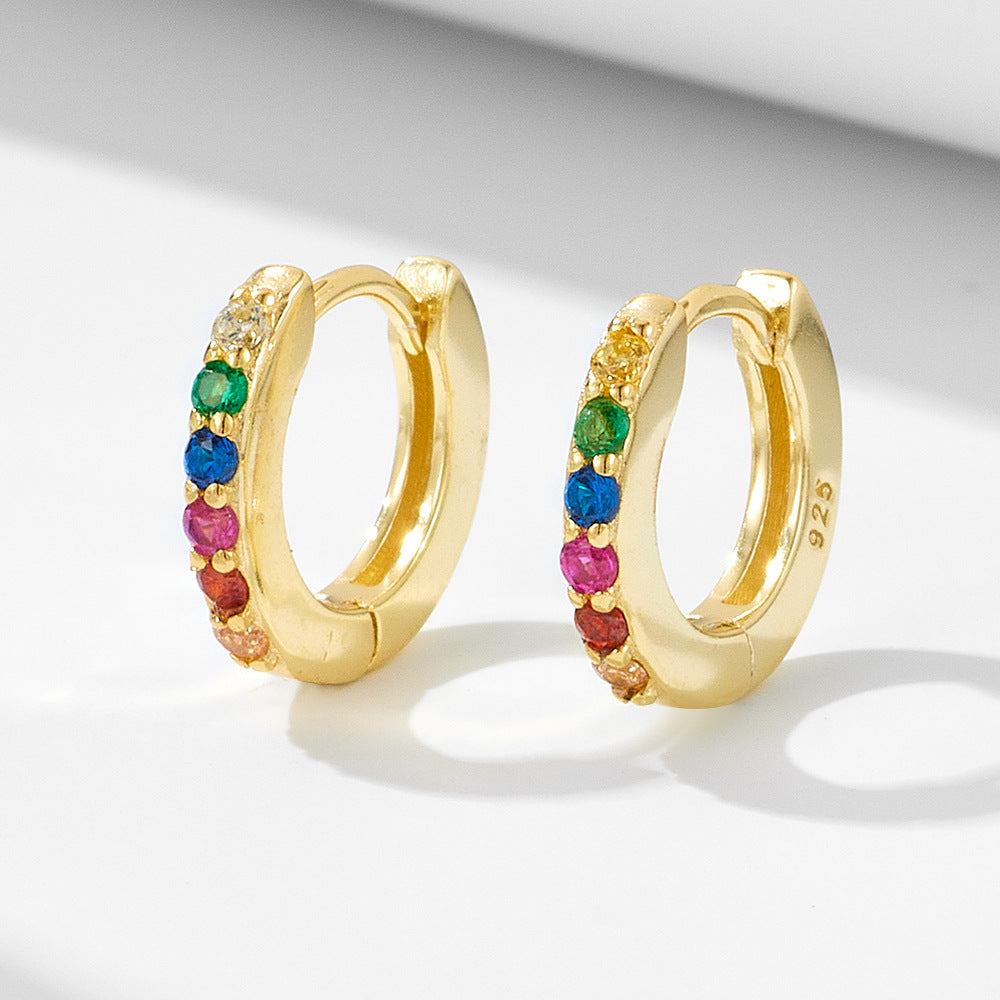 A pair of gold 925 huggie hoop earrings with rainbow gemstones displayed on white background with soft shadow