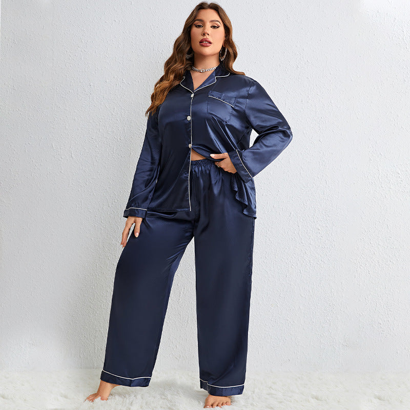 Model in navy blue silk pajama set with white piping trim, wearing crystal necklace against white background