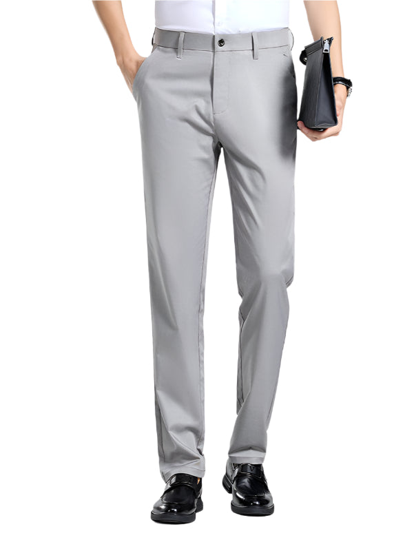 A pair of gray mulberry silk tailored pants with a waistband, held by a person with a white shirt and black shoes.