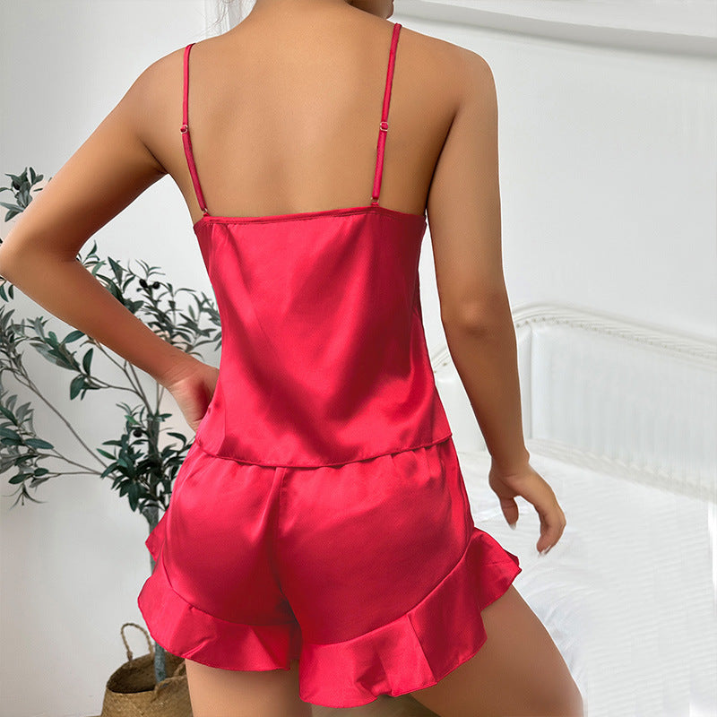 Back view of red silk pajama set showing ruffle-trimmed shorts and adjustable cami straps against white interior