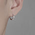 Chain-design silver hoop earring worn on ear, side profile.