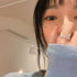 Woman wearing a butterfly ring, partially covering her face with her sleeve