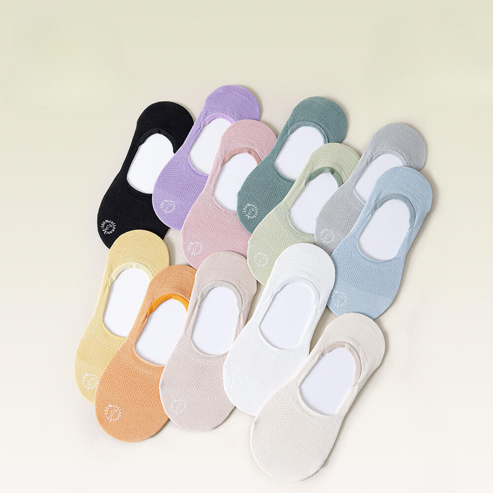 Collection of no-show socks in various pastel shades including black, purple, pink and blue, laid flat with brand logo detail