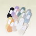 Collection of no-show socks in various pastel shades including black, purple, pink and blue, laid flat with brand logo detail