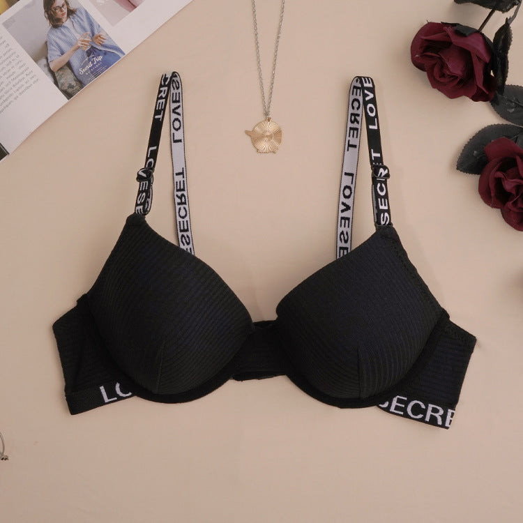 Black ribbed push-up bra with logo elastic straps and branded band trim, styled with gold pendant necklace
