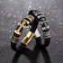 Black braided leather bracelet with gold-tone cross and metallic accents on a glittery background.