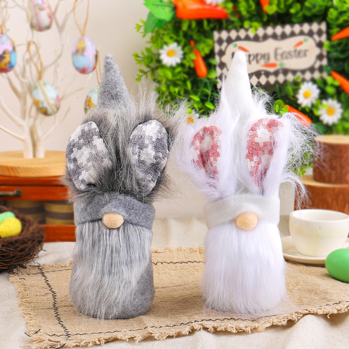 Two plush Easter bunny decorations, one gray and one white, with long ears and beards, displayed on a rustic table with festive decorations.