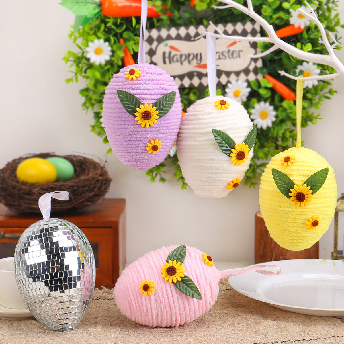 Hanging Easter eggs in pastel colors (purple, white, yellow, and pink) with sunflower and leaf decorations, each measuring 13cm x 10cm.