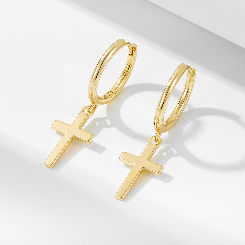 Gold huggie hoop earrings with cross pendants, featuring polished finish and '925' stamp on hoops, displayed on white surface