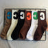 Six pairs of varsity-style crew socks in black, cream, brown, beige, and white, each with a large "C" patch in contrasting colors