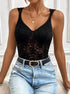 Woman wearing black lace V-neck bodysuit with built-in cups and denim jeans.