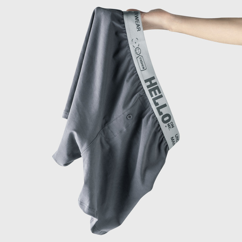 A hand holding gray boxer shorts showing the elastic waistband with 'UNDERWEAR' and 'HELLO' branding