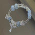 Crystal bracelet with silver butterfly charms and dangling teardrop pendant, made with light blue crackle beads