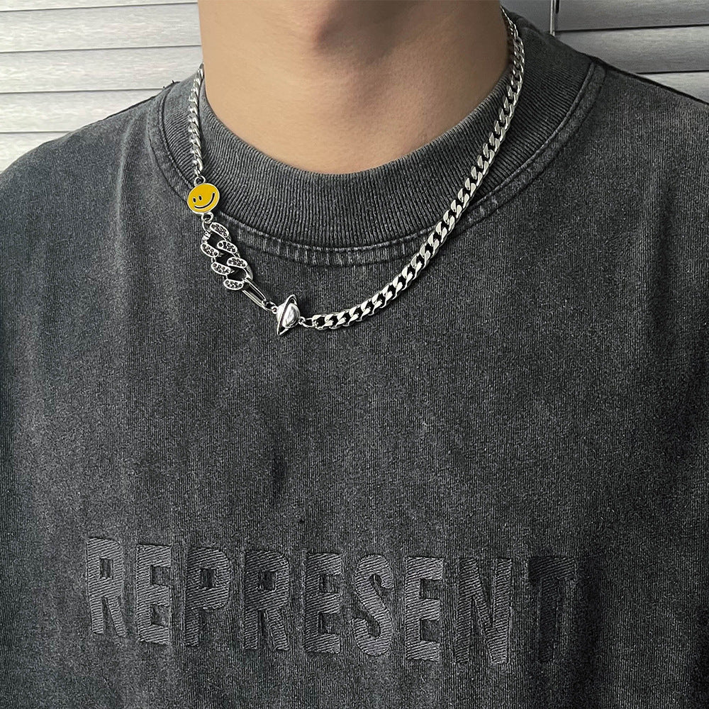 Titanium Steel Cuban chain necklace with yellow smiley face charm and snake design accent, styled on model wearing dark gray Represent sweatshirt