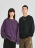 Unisex oversized sweatshirt in purple and black, featuring an embossed logo, soft washed fabric, and a relaxed fit—ideal for casual streetwear