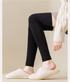 Black ribbed leg warmers with white plush slippers, worn with knit sweater