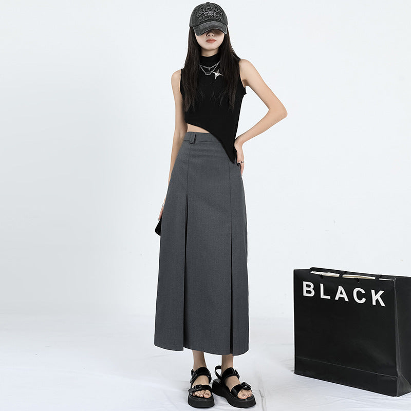 Full-length shot showing charcoal gray pleated maxi skirt with ankle-length hem and tailored waistband