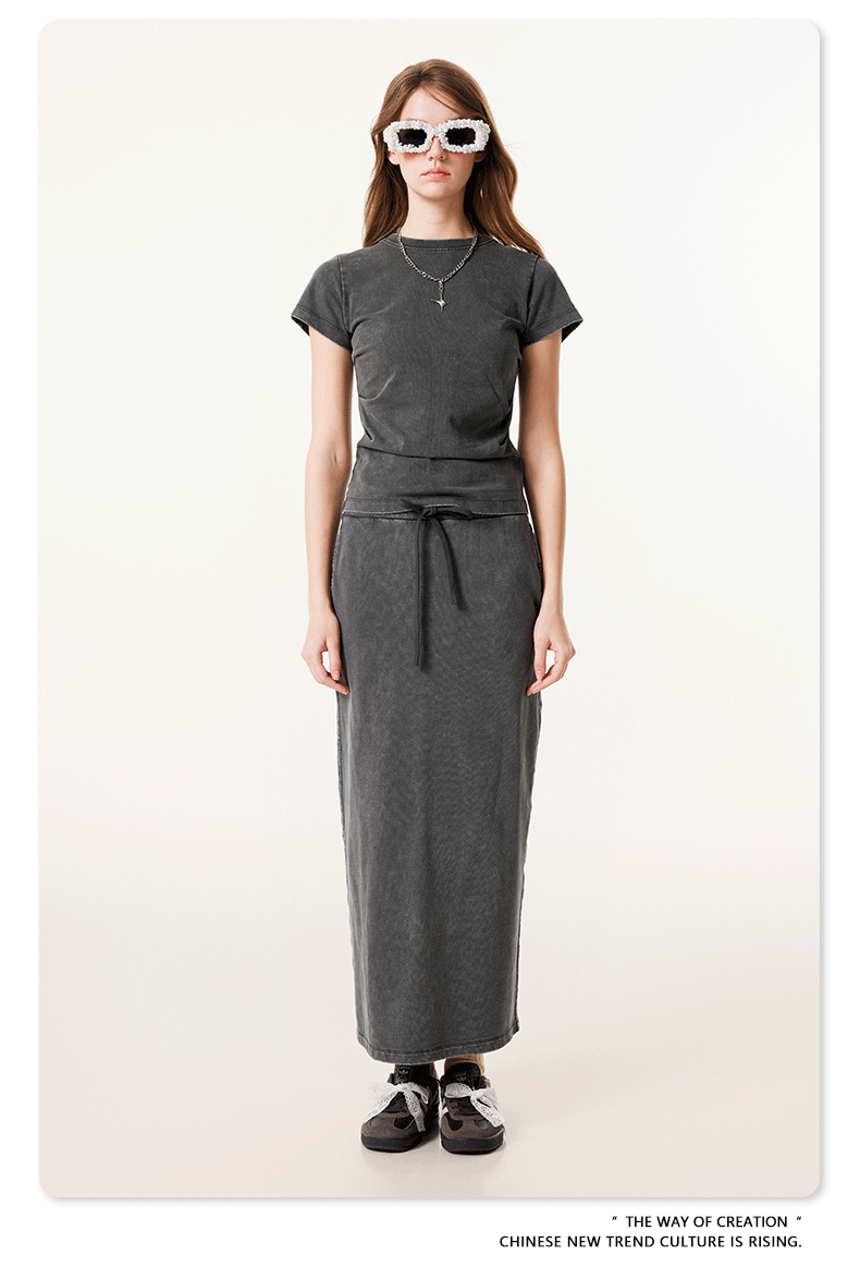 Dark gray long denim skirt and matching short-sleeve top, with white bow-tied sneakers and oversized white sunglasses