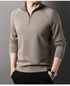 Close-up of taupe quarter-zip pullover sweater showing collar detail and silver zipper pull against neutral background
