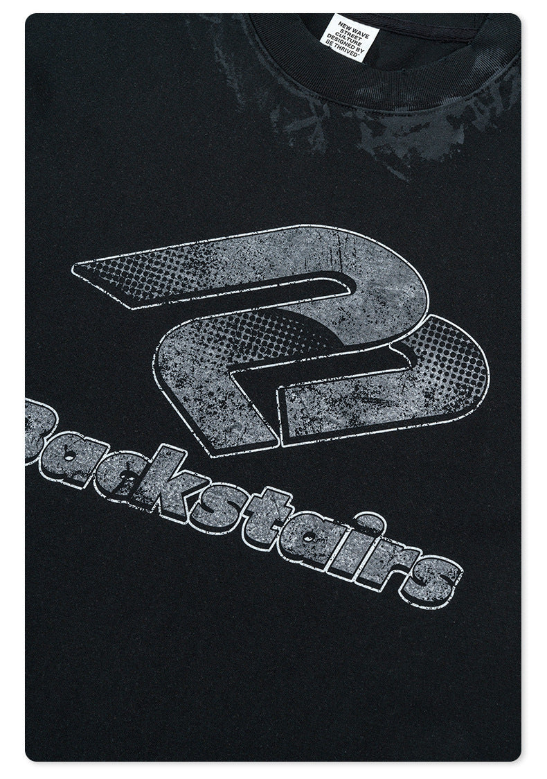 Detail of distressed Backstairs logo print with halftone effect on black t-shirt